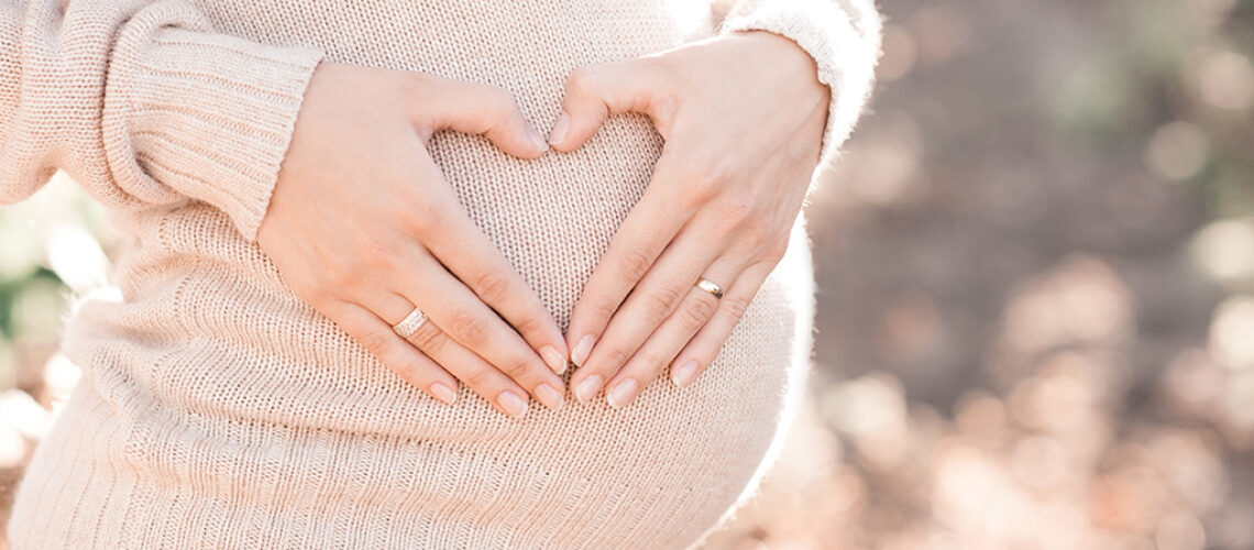 pregnant-woman-tummy-with-hands-in-heart-shape-out-of-her-hands